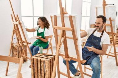 Resim stüdyosunda gülümseyen iki orta yaşlı öğrenci..