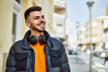 Yakışıklı, sakallı, neşeli ve kendine güvenen, kışlık palto giyen bir İspanyol.