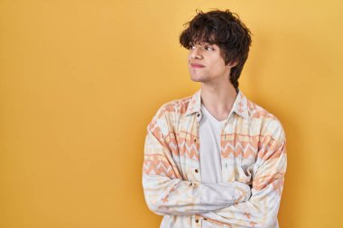 Young man wearing casual summer shirt smiling looking to the side and staring away thinking. 