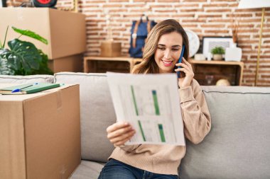 Yeni evdeki akıllı telefon okuma dokümanında konuşan genç bir kadın.