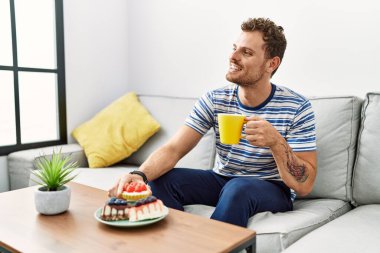 Genç İspanyol adam evde kahvaltı ederken kendine güveniyor.