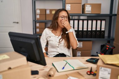 Küçük işletmelerde çalışan Latin kökenli genç bir kadın ağzıyla esnemekten sıkılmış. Huzursuz ve uykulu.. 