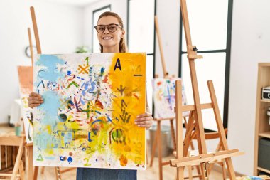 Resim stüdyosunda kendine güveni olan genç bir kadın.