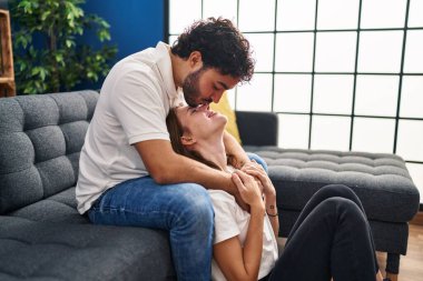 Erkek ve kadın öpüşüyor. Evlerinde birbirlerine sarılıyorlar.