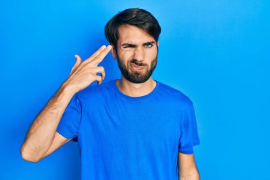 Gündelik giysiler giymiş genç İspanyol bir adam kendini vuruyor ve öldürüyor. Elini ve parmaklarını silah gibi kullanıyor. İntihar jesti.. 