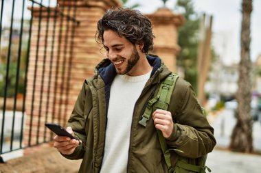 Şehirde akıllı telefon kullanan yakışıklı bir İspanyol.