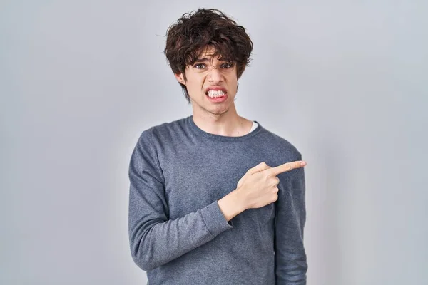 Young Man Standing Isolated Background Pointing Aside Worried Nervous Forefinger — Φωτογραφία Αρχείου