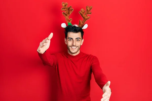 Νεαρός Ισπανός Που Φοράει Χαριτωμένα Χριστουγεννιάτικα Κέρατα Ταράνδων Κοιτάζοντας Την — Φωτογραφία Αρχείου