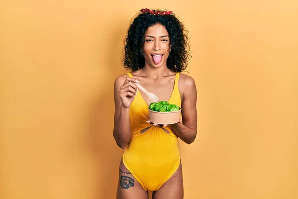 Young Latin Girl Wearing Swimsuit Eating Salad Sticking Tongue Out — 图库照片