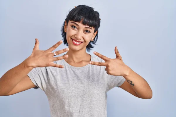 Jovem Hispânica Vestindo Camiseta Casual Sobre Fundo Azul Mostrando Apontando — Fotografia de Stock