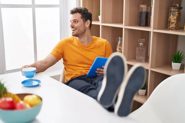 Jovem Hispânico Usando Touchpad Bebendo Café Casa — Fotografia de Stock