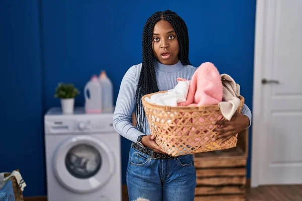 African American Woman Holding Laundry Basket Scared Amazed Open Mouth —  Fotos de Stock