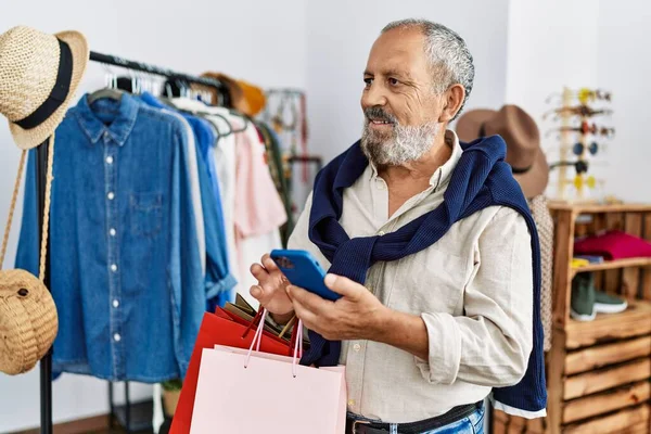 Senior Grey Haired Man Holding Shopping Bags Using Smartphone Clothing — Stockfoto