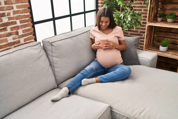 Young Latin Woman Pregnant Drinking Coffee Sitting Sofa Home — Stock fotografie