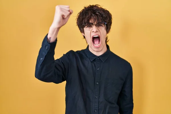Young Man Wearing Glasses Yellow Background Angry Mad Raising Fist — Stockfoto
