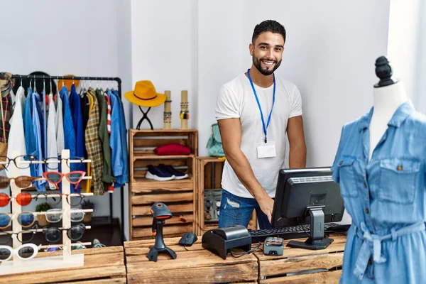 年轻的阿拉伯男子店主带着自信的笑容在服装店工作 — 图库照片
