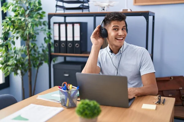 Young Hispanic Man Working Office Wearing Headphones Smiling Hand Ear — Foto Stock