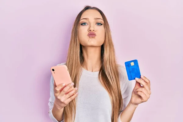 Młoda Blondynka Trzymająca Smartfona Nadęte Policzki Zabawną Twarzą Usta Napompowane — Zdjęcie stockowe