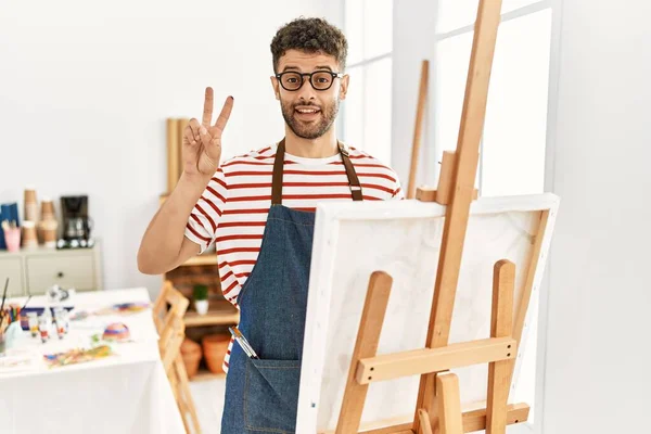 Sanat Stüdyosunda Gülümseyen Kameraya Göz Kırpan Arap Genç Adam Parmaklarıyla — Stok fotoğraf