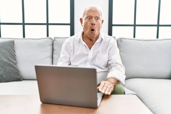 Senior Man Using Laptop Home Sitting Sofa Afraid Shocked Surprise — Foto de Stock