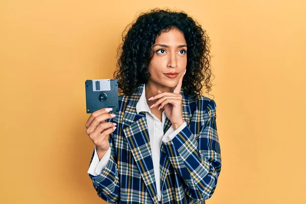 Young Latin Girl Holding Floppy Disk Serious Face Thinking Question — 图库照片