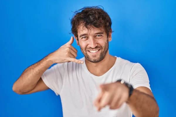 Jovem Hispânico Sobre Fundo Azul Sorrindo Fazendo Falar Gesto Telefone — Fotografia de Stock