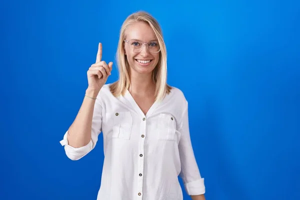 Молодая Белая Женщина Стоящая Синем Фоне Указывая Пальцем Успешную Идею — стоковое фото