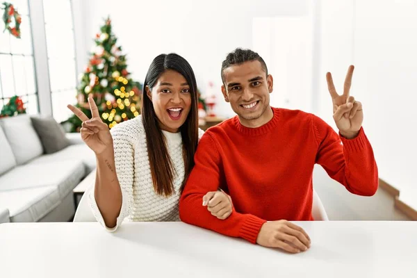 Jong Latijns Echtpaar Zit Tafel Bij Kerstboom Glimlachend Met Vrolijk — Stockfoto