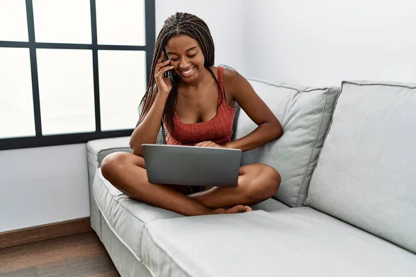 Young African American Woman Using Laptop Talking Smartphone Home — Fotografia de Stock