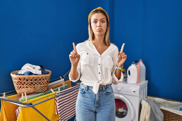 Young Blonde Woman Laundry Room Pointing Looking Sad Upset Indicating — Stockfoto