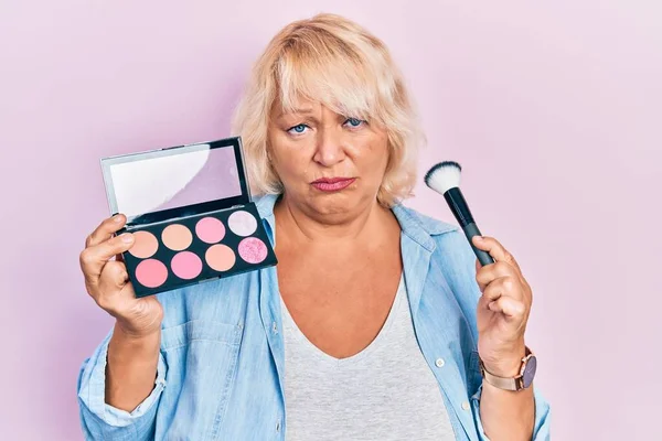 Middle Age Blonde Woman Holding Makeup Brush Blush Depressed Worry — Stockfoto