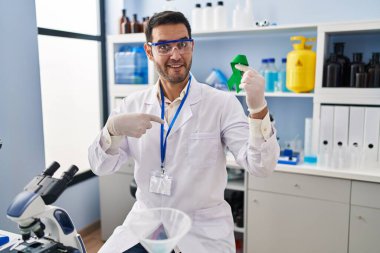 Sakallı, sakallı, bilim adamı elinde yeşil kurdeleyle mutlu ve gururlu bir kişiyi işaret eden genç bir İspanyol. 