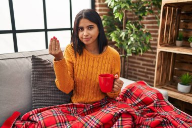 Genç İspanyol kadın kanepede oturup kahvesini yudumluyor. İtalyan jestleri yapıyor. Elleri ve parmakları kendinden emin bir ifadeyle. 