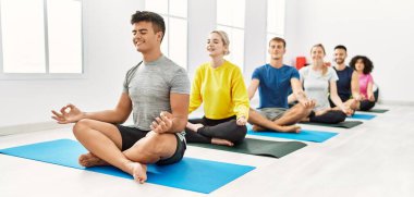 Spor merkezinde mutlu bir yoga eğitimi veren bir grup genç..