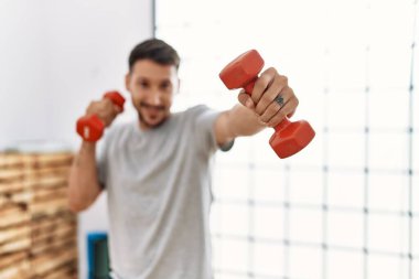 Genç İspanyol adam gülümsüyor spor merkezinde kendine güvenen bir antrenman