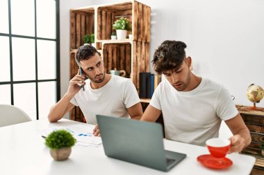 İki İspanyol çift akıllı telefondan konuşuyor ve evde bilgisayar kullanıyorlar.