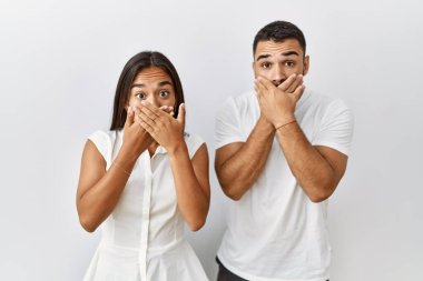 Soyutlanmış arka planda birbirine aşık iki ırk arası genç çift, ağızlarını yanlışlıkla ağızlarıyla kapatarak şok geçirdiler. gizli kavram. 