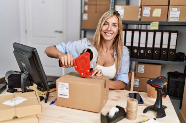 Genç sarışın kadın ecommerce iş işçisi ofiste paket paketleme