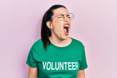 Gönüllü tişört giyen genç İspanyol kadın kızgın ve kızgın bağırıyor öfkeyle bağırıyor. öfke ve agresif konsept. 