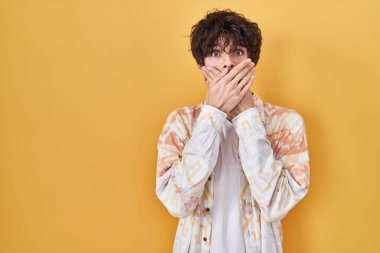 Young man wearing casual summer shirt shocked covering mouth with hands for mistake. secret concept. 