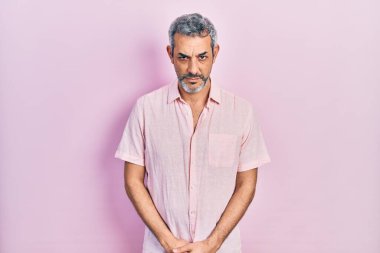 Gri saçlı, sıradan tişörtlü, kuşkucu ve sinirli, sorunlu, orta yaşlı yakışıklı bir adam. negatif kişi. 