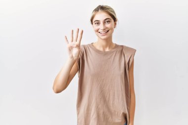 İzole edilmiş arka planda duran genç sarışın kadın kendini beğenmiş ve mutlu bir şekilde gülümserken dört numarayı işaret ediyor.. 