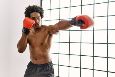 Genç Afrikalı Amerikalı adam spor salonunda boks yapıyor.