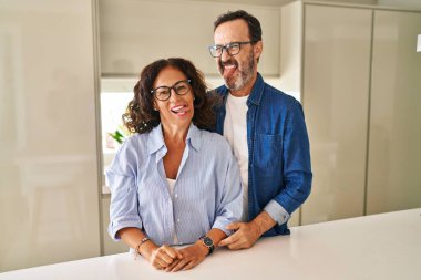 Orta yaşlı çift yan yana durmuş, komik bir ifadeyle dillerini dışarı çıkarıyorlar. duygu kavramı. 