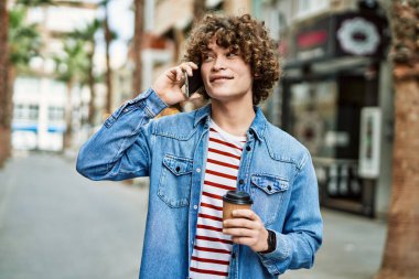 Genç İspanyol adam şehirde telefonla konuşuyor.