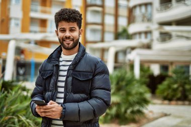 Kasabada akıllı telefon kullanan genç bir Arap.