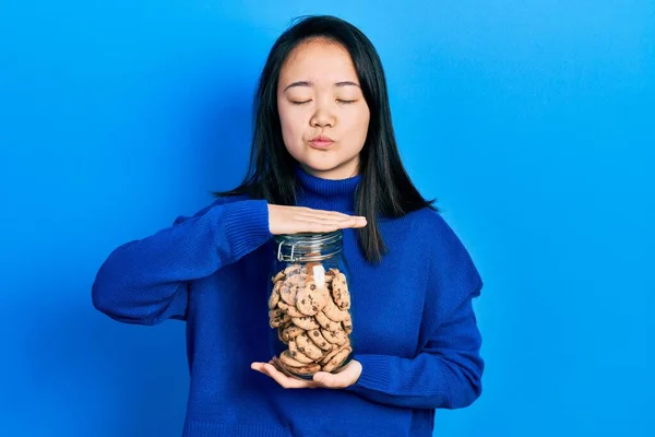 Jong Chinees Meisje Met Een Pot Chocoladechips Koekjes Kijkend Naar — Stockfoto