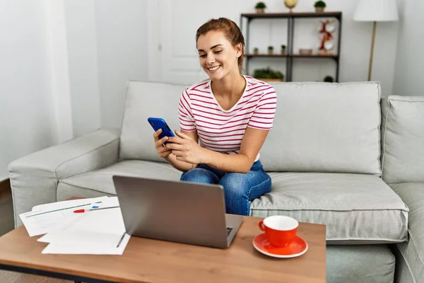 Junge Frau Arbeitet Mit Smartphone Und Laptop Hause Auf Sofa — Stockfoto