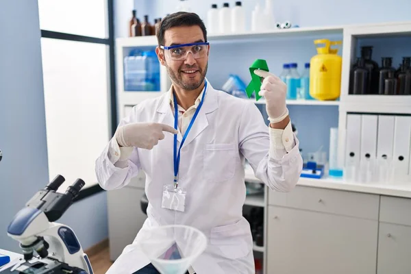 Young Hispanic Man Beard Working Scientist Laboratory Holding Green Ribbon — Stockfoto