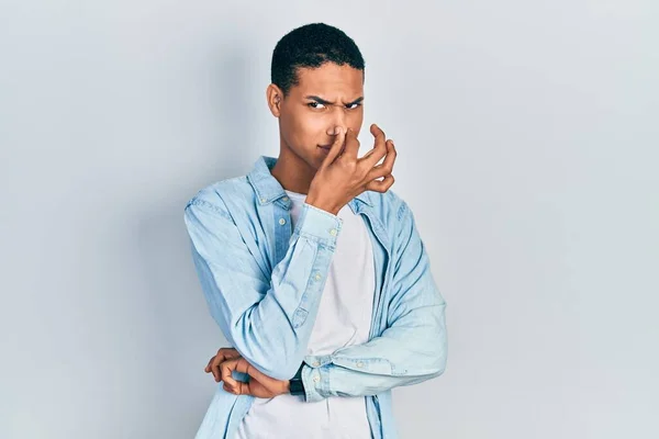 Jovem Afro Americano Vestindo Roupas Casuais Cheirando Algo Fedorento Nojento — Fotografia de Stock